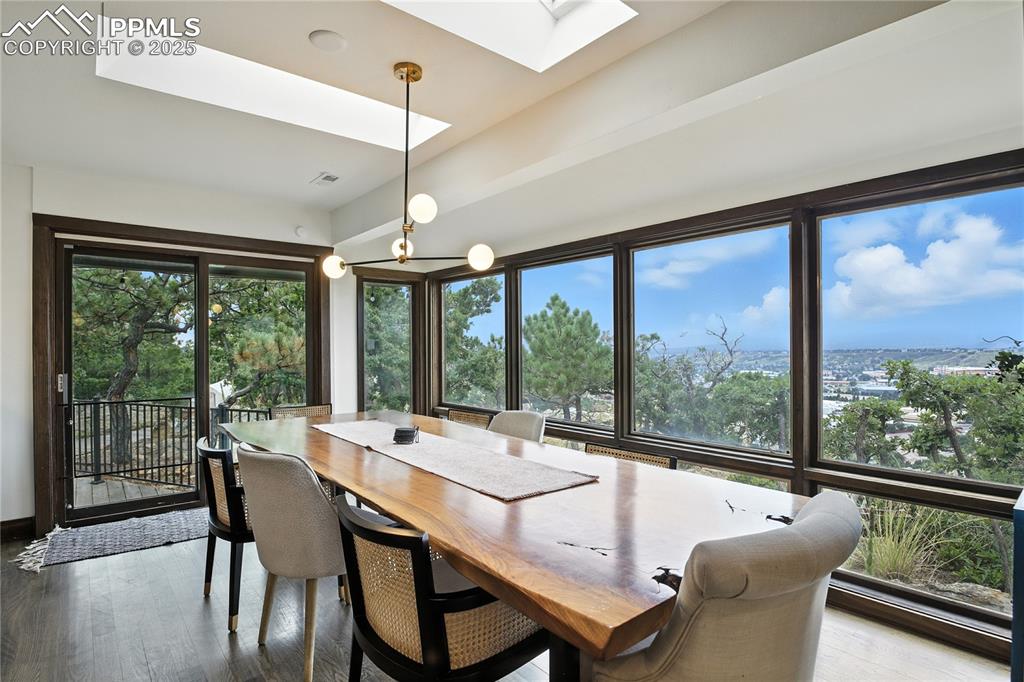 Image 3 of 50: Dining area with a skylight and dark wood-style floors