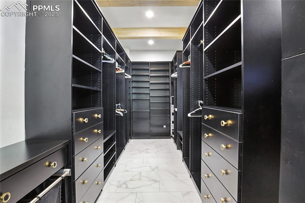 Image 31 of 50: Walk in closet with light marble finish floors