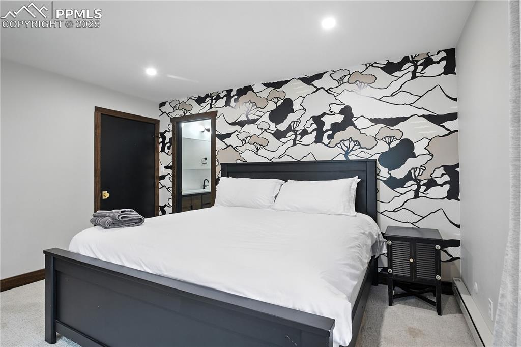 Image 34 of 50: Bedroom with light carpet, a baseboard radiator, recessed lighting, and an 