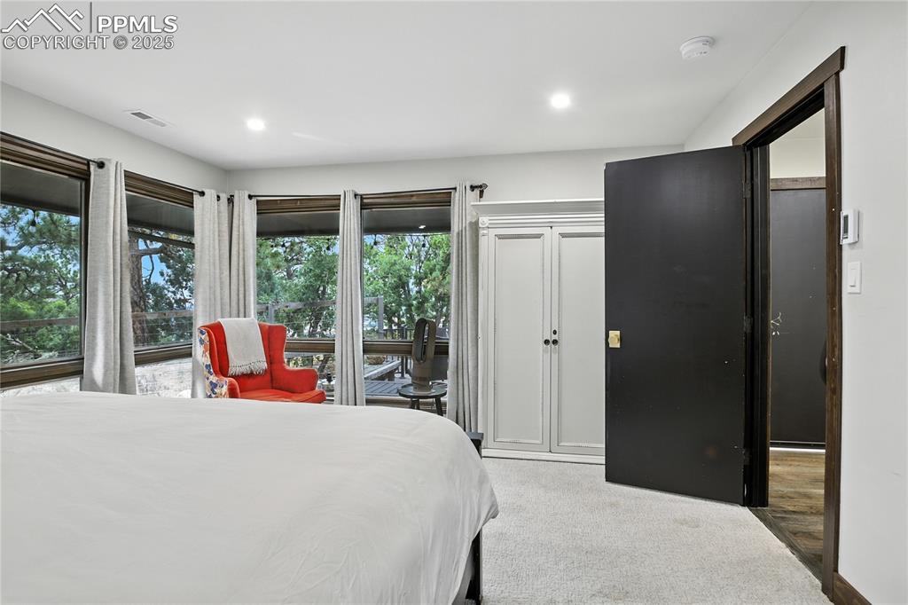 Image 35 of 50: Bedroom with light colored carpet and recessed lighting