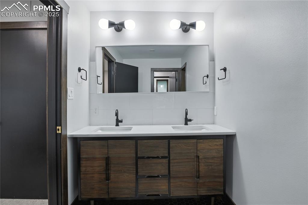 Image 36 of 50: Bathroom with decorative backsplash and double vanity