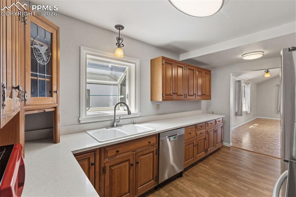 Image 17 of 50: Kitchen featuring wood-finish flooring, light-toned countertops, a double b