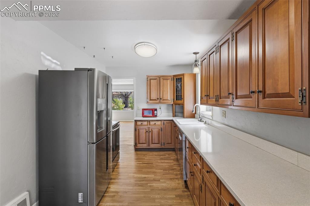 Image 18 of 50: Kitchen featuring stainless steel appliances, wood-finish flooring, light-t