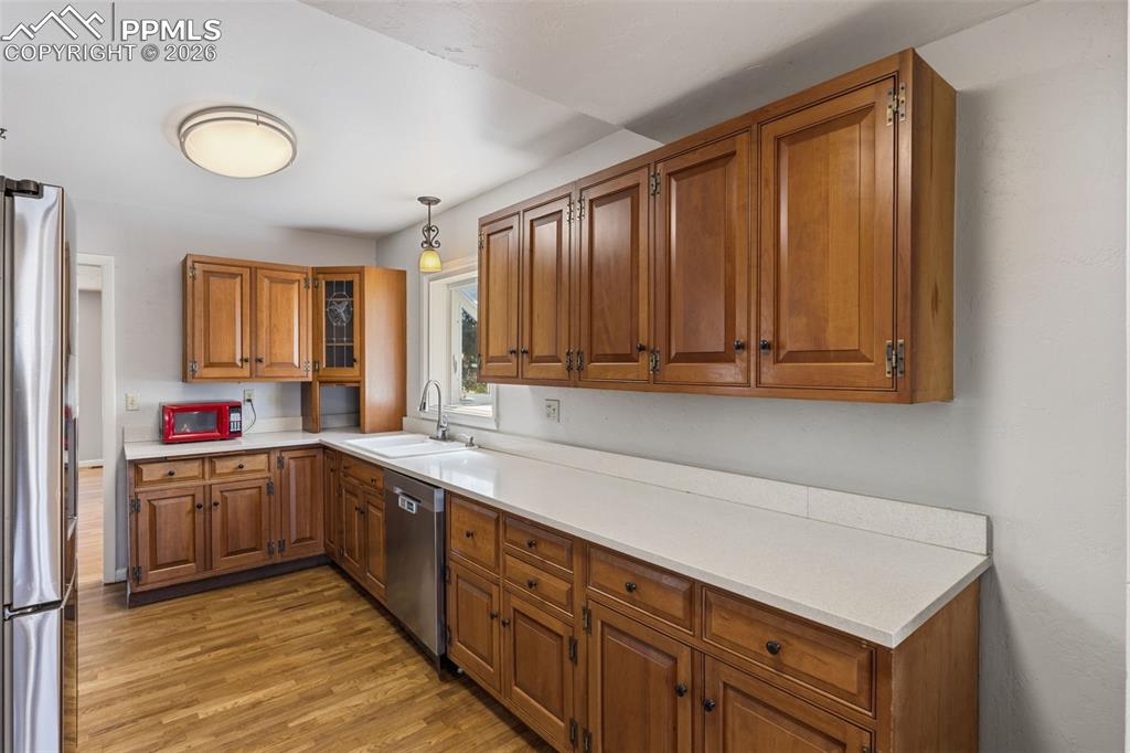 Image 19 of 50: Kitchen featuring wood-finish cabinetry, light-toned countertops, and wood-