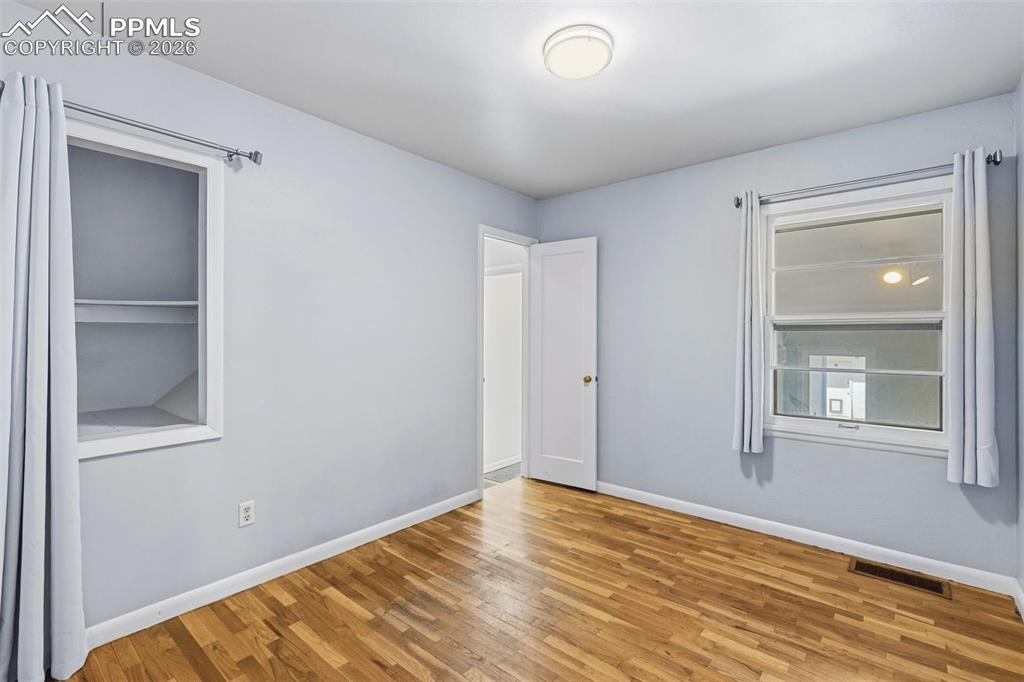Image 22 of 50: Room featuring wood-finish flooring, light blue walls, and white trim