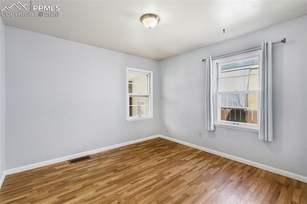 Image 23 of 50: Hardwood flooring throughout featuring light gray walls, white trim, and tw