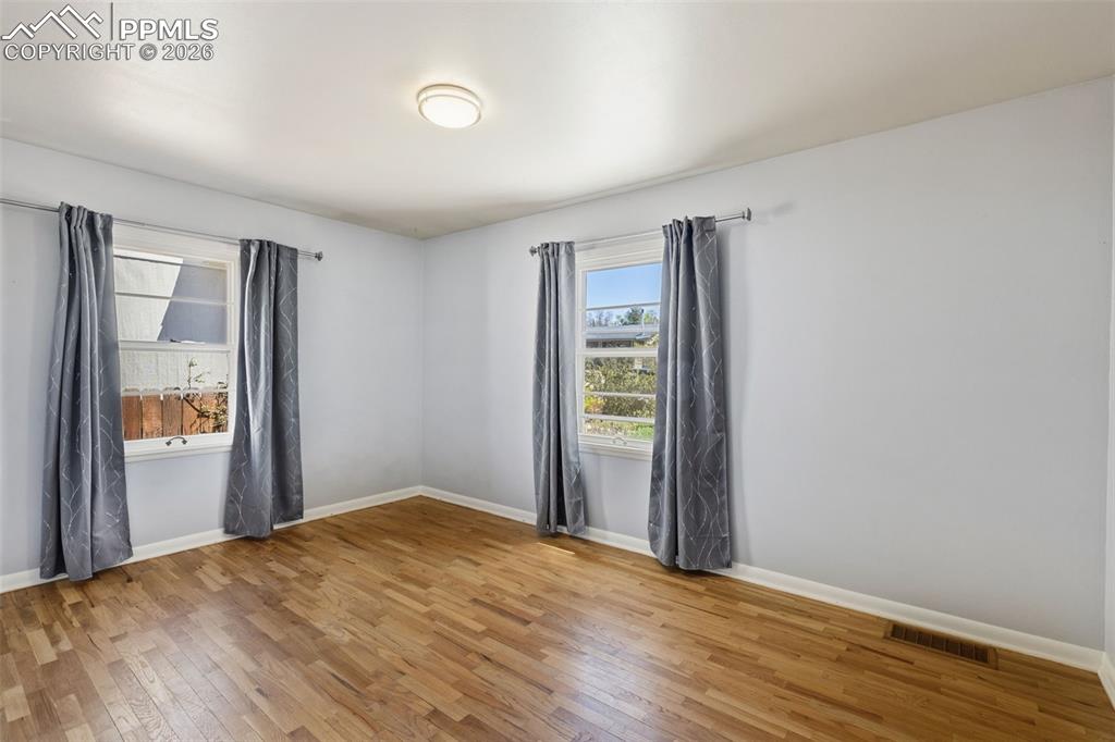 Image 24 of 50: Bright room featuring wood-finish flooring and light-colored walls