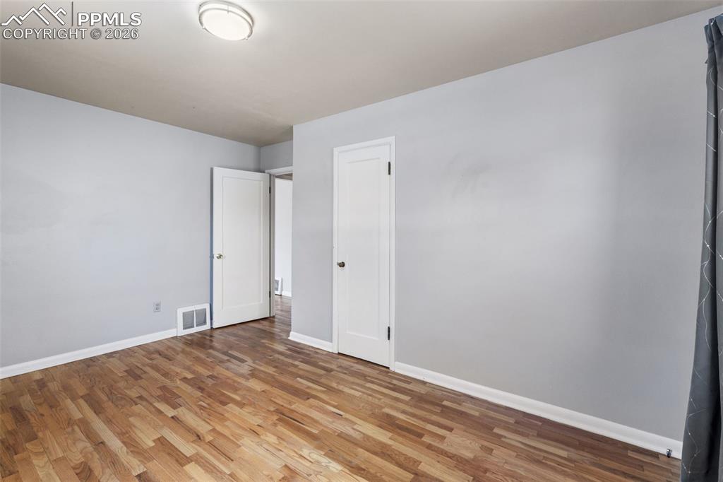 Image 25 of 50: Hardwood flooring throughout, light gray wall finishes, white trim, and a f