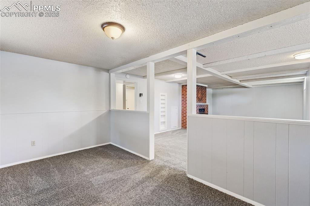 Image 33 of 50: Carpeted room with a textured ceiling and a flush-mount light fixture
