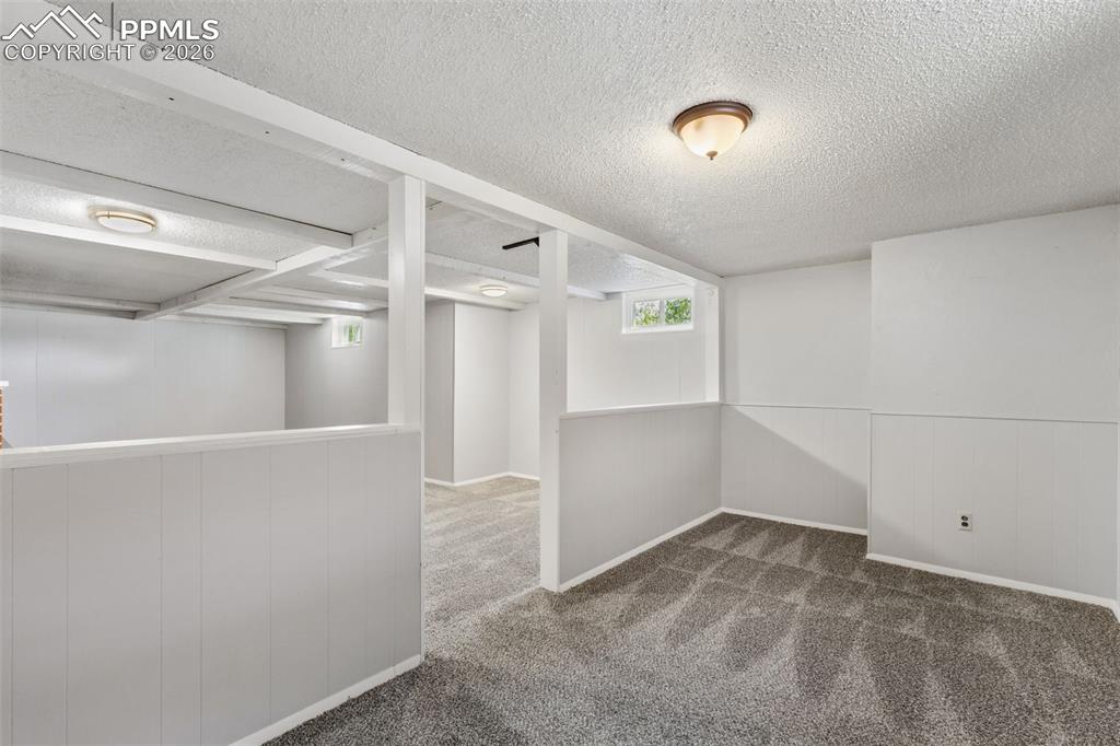 Image 34 of 50: Finished basement area featuring newly installed gray carpeting, white pane