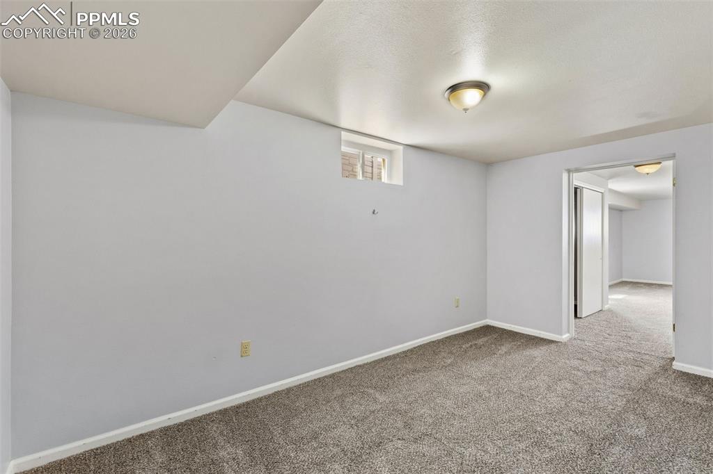 Image 35 of 50: Finished lower level space featuring gray wall paint, gray carpet, a window