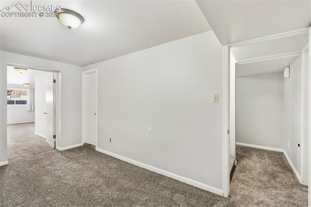 Image 36 of 50: Interior room featuring light gray walls, gray carpet, and white trim