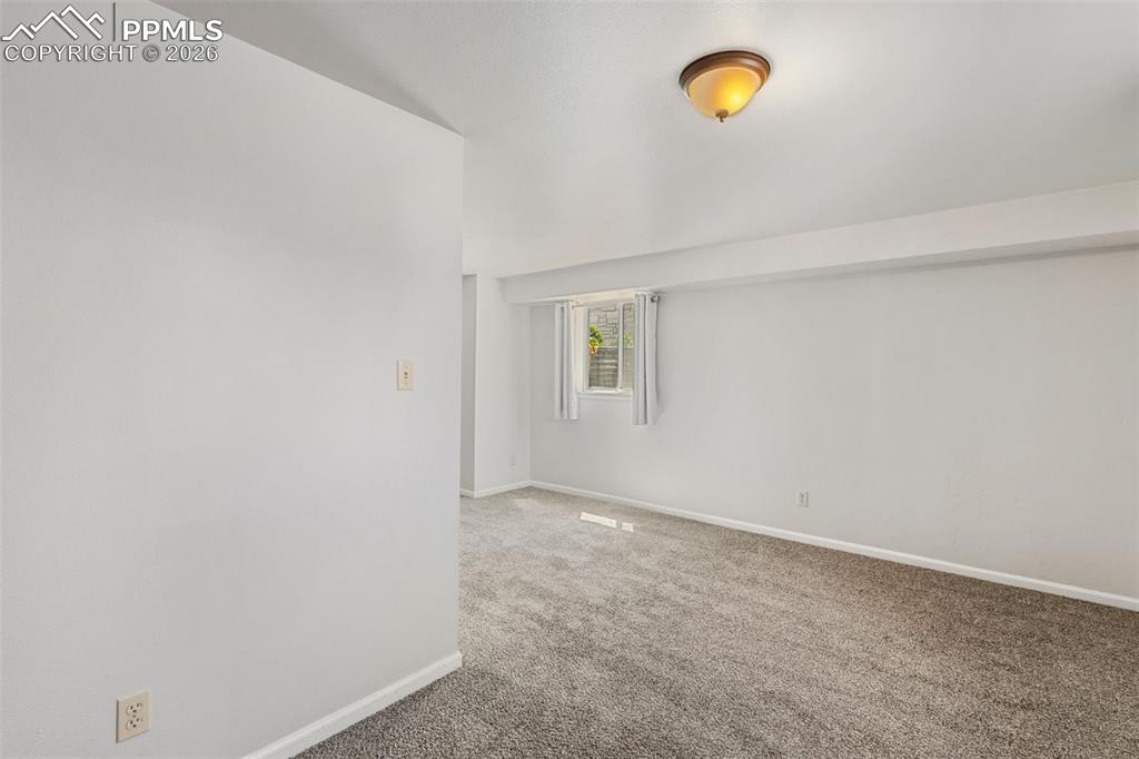 Image 42 of 50: Carpeted interior space featuring white walls, a single window, and a flush