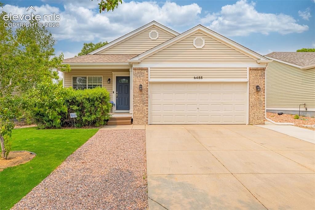 Image 1 of 49: Exterior featuring beige siding, brick accents, an attached garage, a dark