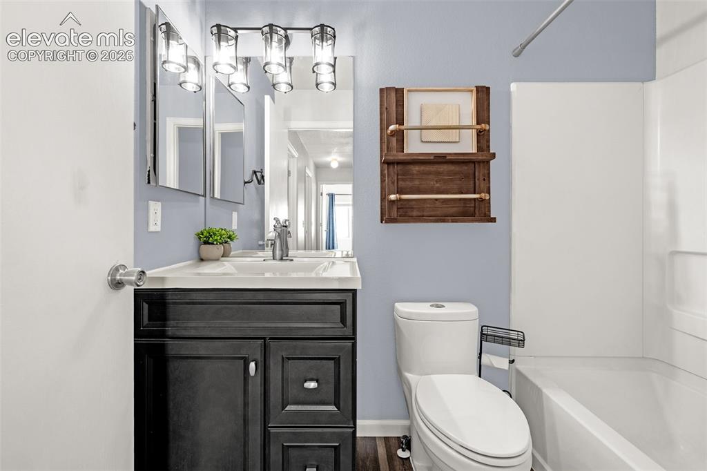 Image 12 of 49: Room featuring wood-finish flooring, a bright window with privacy film, and