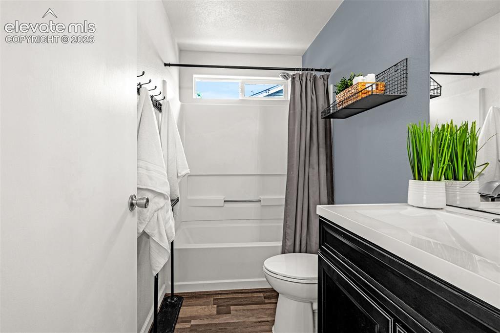 Image 14 of 49: Bedroom featuring wood-finish flooring, a contemporary window with decorati