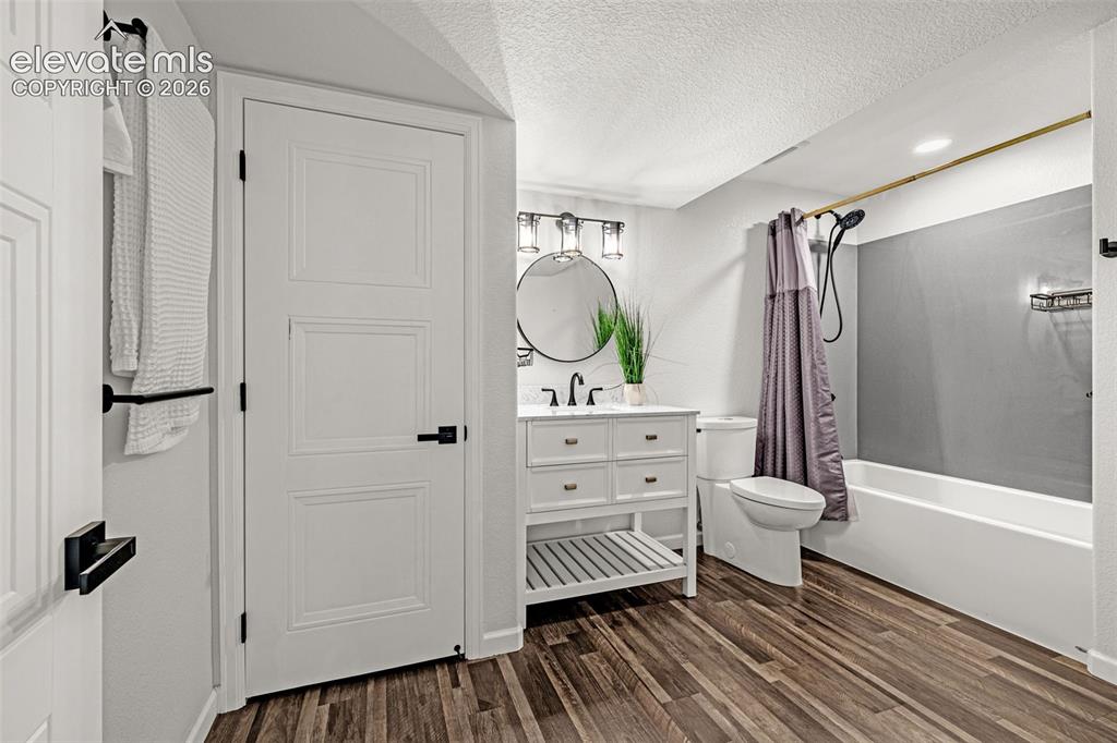Image 27 of 49: bathroom adjoins basement bedroom featuring a white vanity with integrated