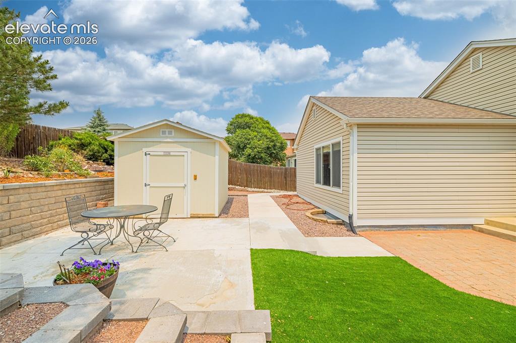 Image 34 of 49: Rear exterior featuring horizontal siding, a fenced yard, a brick paver pat