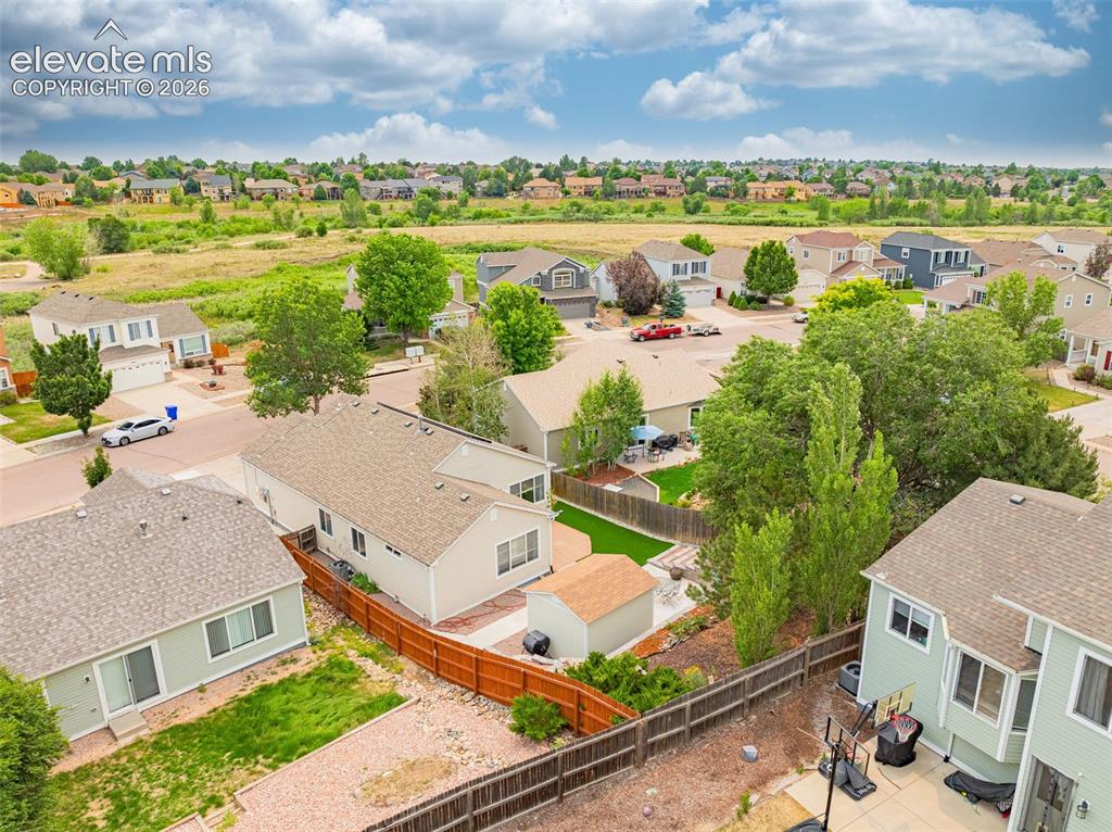Image 40 of 49: Property featuring a shingle roof with solar panels, a concrete driveway, a