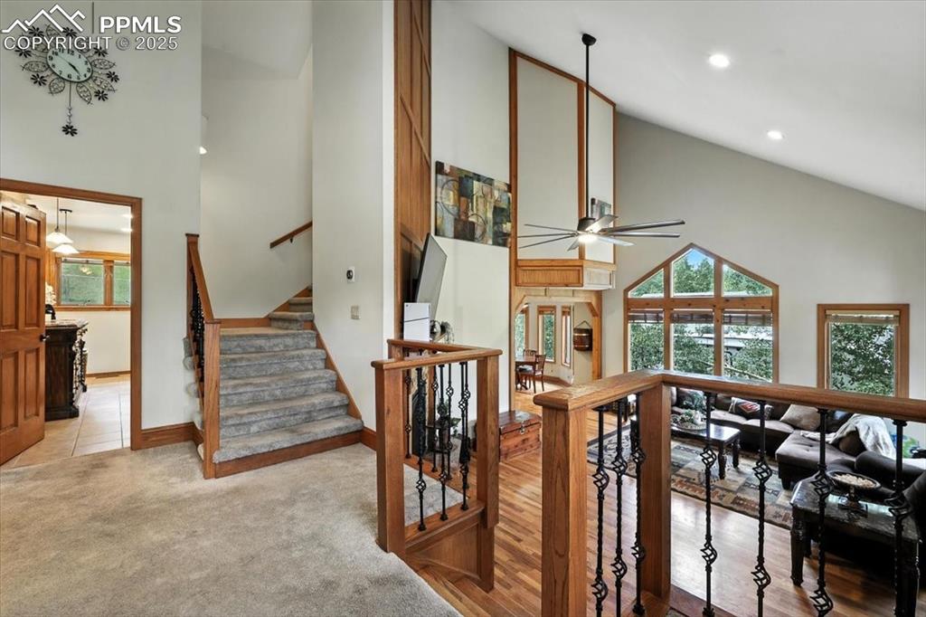 Image 13 of 36: Stairs with high vaulted ceiling, a ceiling fan, plenty of natural light, c