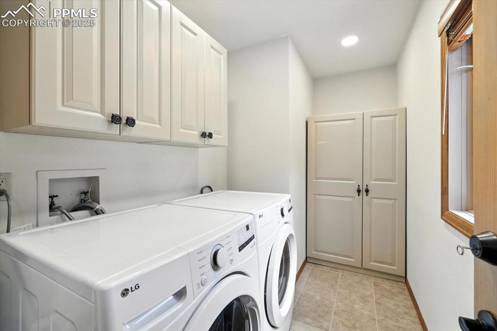 Image 18 of 36: Washroom featuring washer and clothes dryer, cabinet space, recessed lighti
