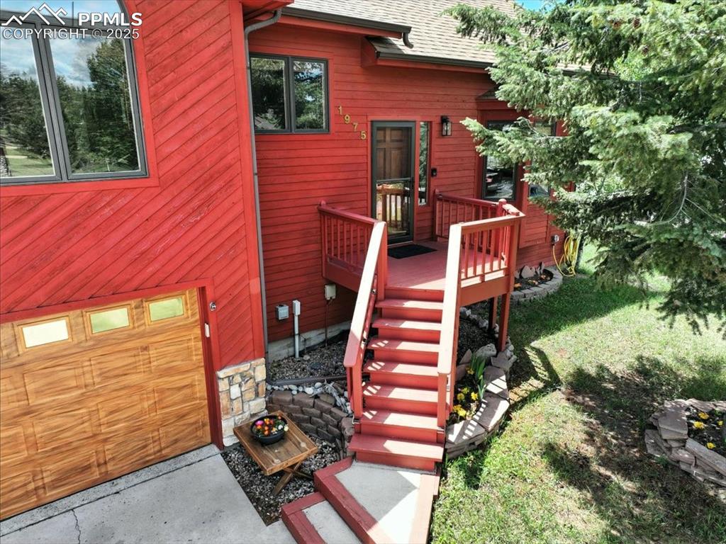 Image 2 of 36: Entrance to property with roof with shingles and a wooden deck