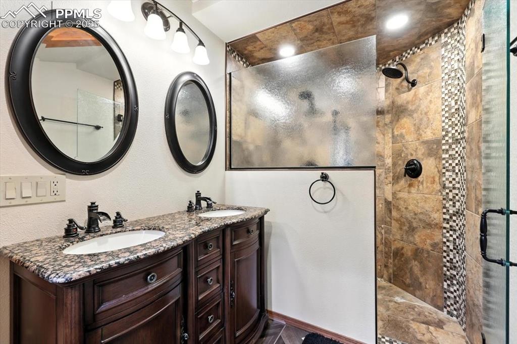 Image 22 of 36: Full bath with a tile shower and double vanity