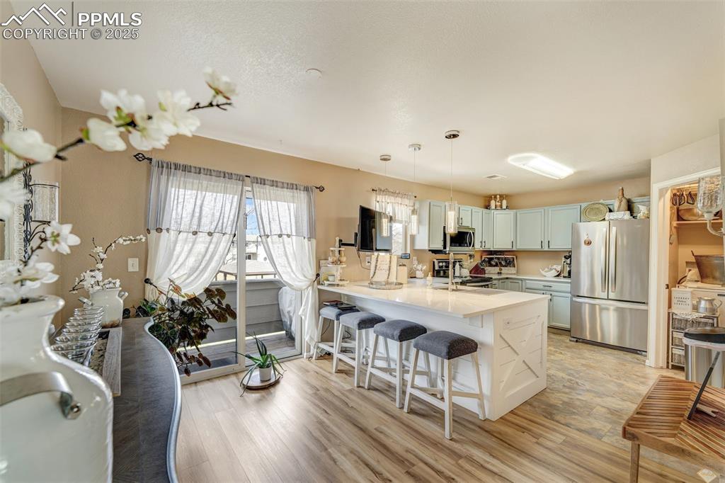 Image 6 of 23: Kitchen featuring a breakfast bar, light wood-type flooring, a peninsula, l
