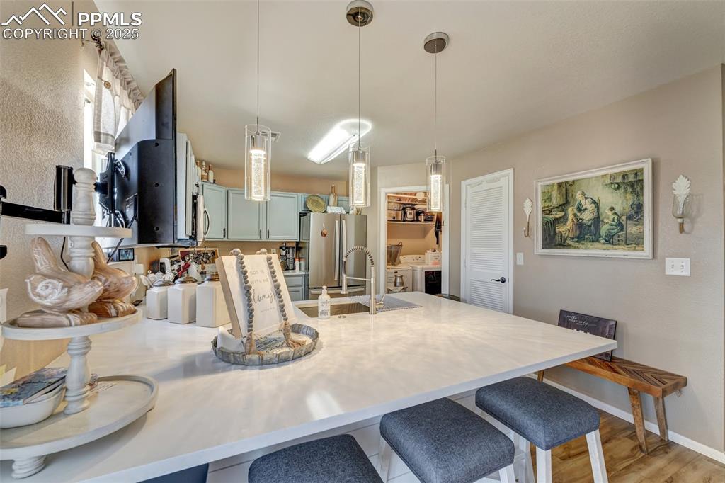 Image 7 of 23: Kitchen with a sink, light countertops, appliances with stainless steel fin