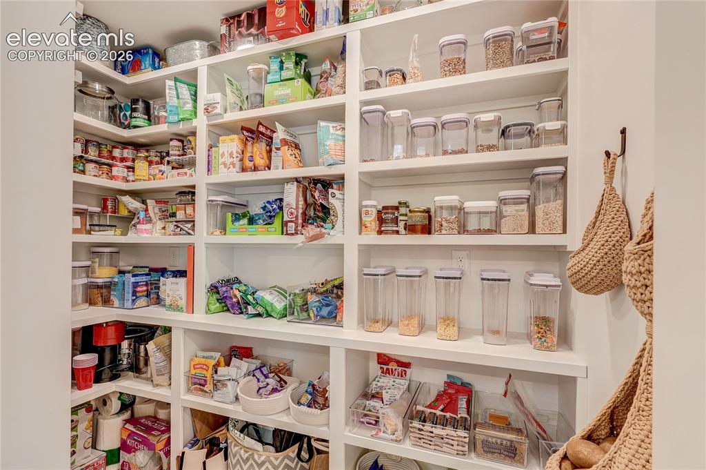 Image 15 of 50: Expansive pantry featuring white built-in shelving, providing ample storage