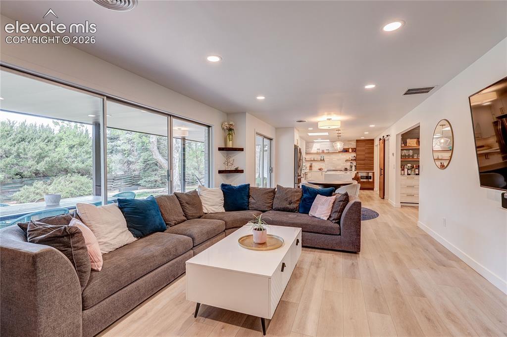 Image 17 of 50: Recessed lighting, wood-finish flooring, and large sliding glass doors