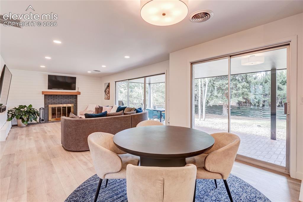 Image 19 of 50: Open-concept interior featuring wood-finish flooring, a fireplace with a da