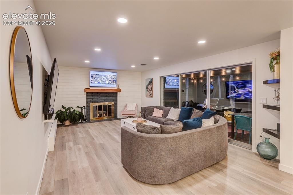 Image 20 of 50: Recessed lighting illuminates the wood-finish flooring and shiplap accent w