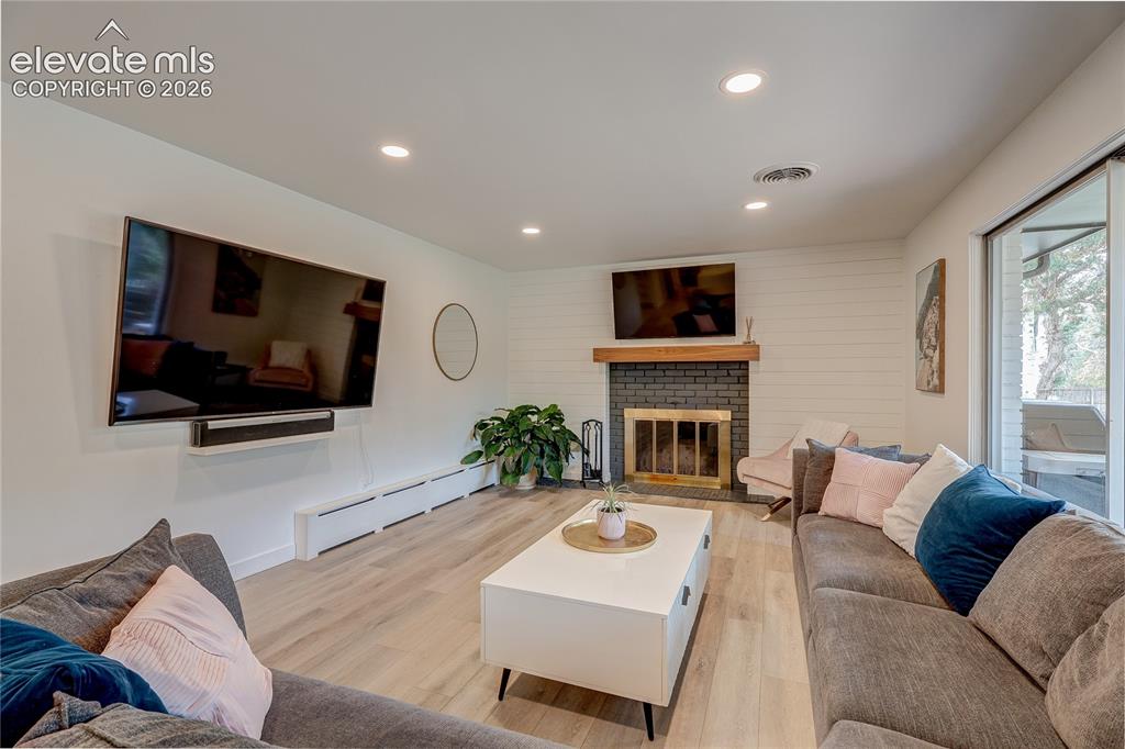 Image 22 of 50: Spacious living area featuring wood-finish flooring, recessed lighting, and