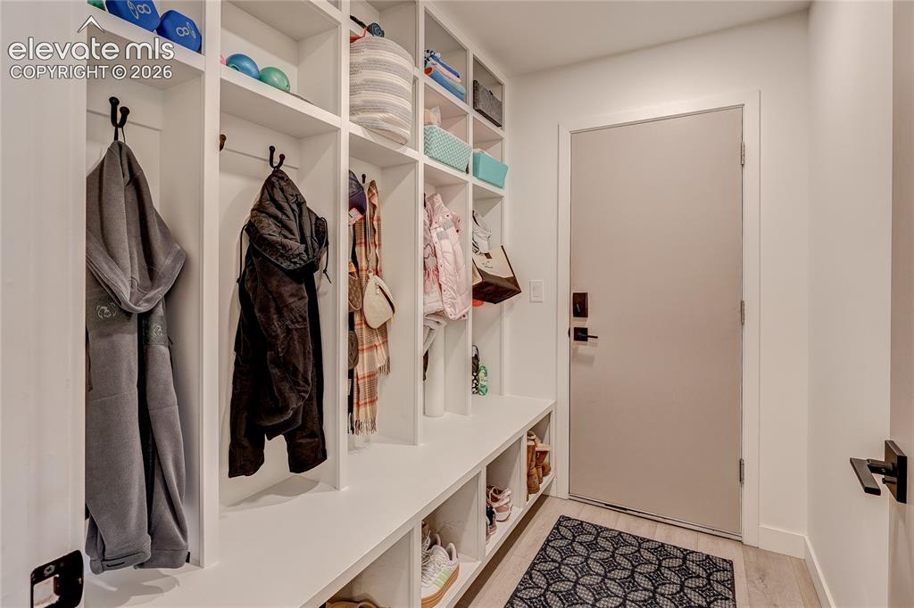 Image 23 of 50: Built-in mudroom storage with integrated shelving, hooks, and bench seating