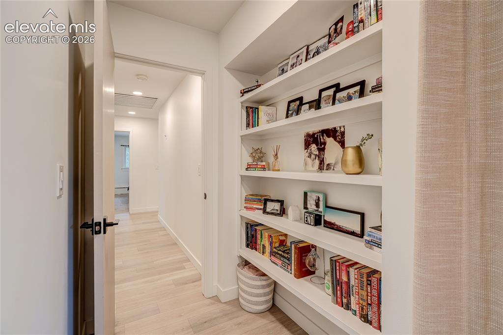 Image 24 of 50: Built-in shelving with multiple display tiers, recessed ceiling lighting, l