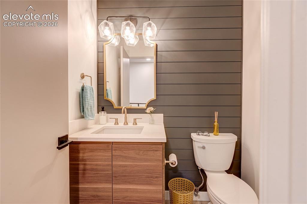 Image 27 of 50: Wood-finish vanity with an undermount sink and light-toned countertop
