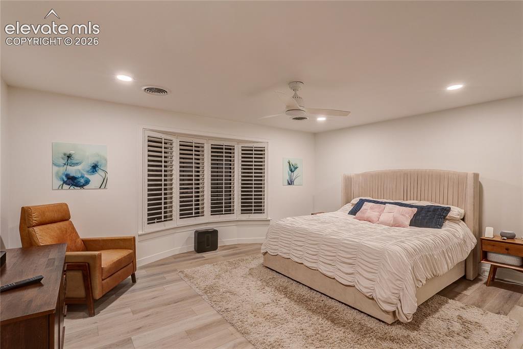 Image 32 of 50: Recessed lighting, ceiling fan, wood-finish flooring, bay window with plant