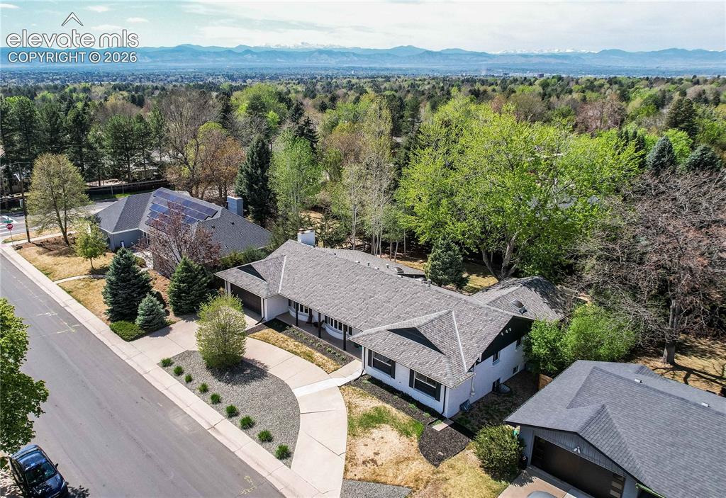 Image 4 of 50: Paved driveway with curb appeal landscaping, mature trees, and a shingle ro