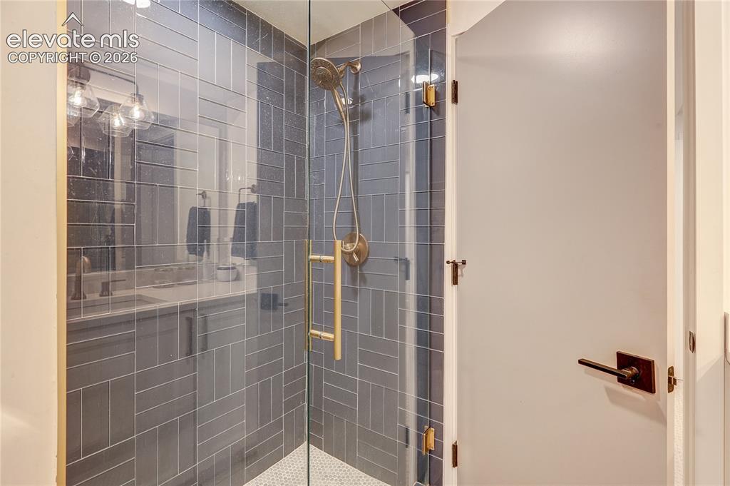 Image 49 of 50: Glass-enclosed shower with subway tile surround, hexagonal mosaic floor til