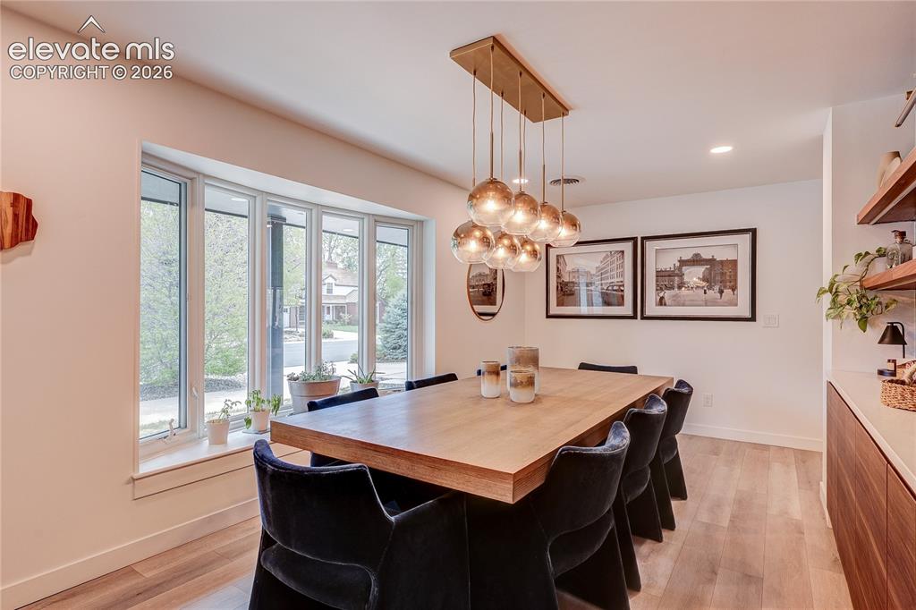 Image 5 of 50: Bay window, wood-finish flooring, recessed lighting, and a modern chandelie