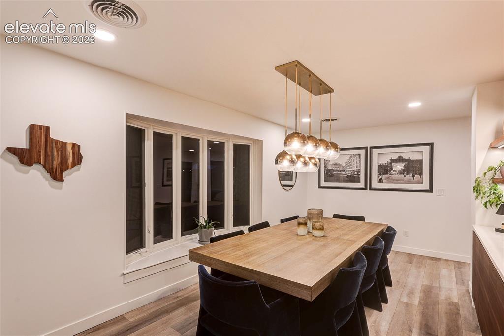 Image 8 of 50: Dining area featuring wood-finish flooring, recessed lighting, a multi-ligh