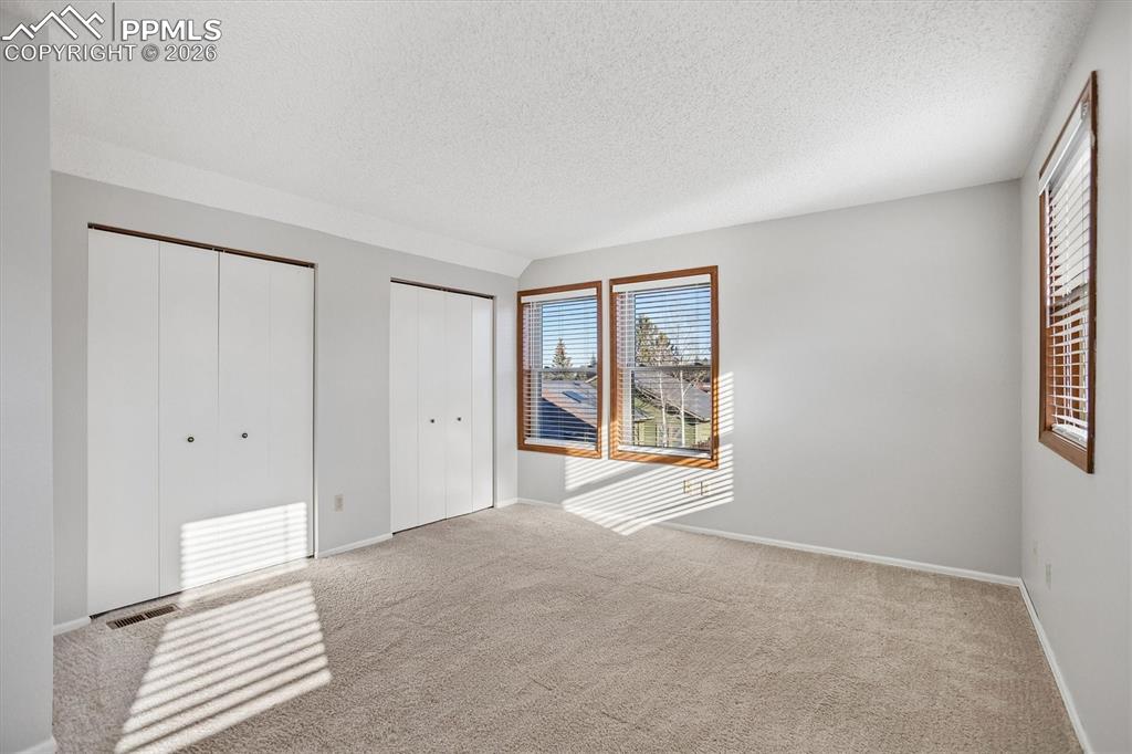 Image 15 of 29: Unfurnished bedroom with multiple closets and light carpet