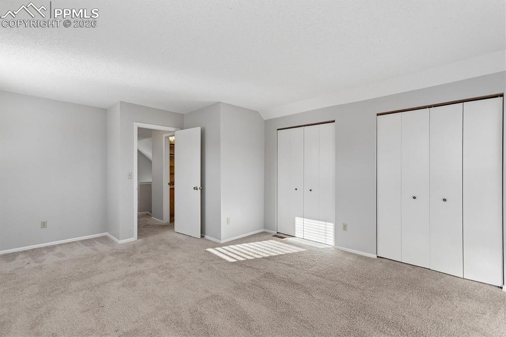 Image 16 of 29: Unfurnished bedroom with two closets and light carpet