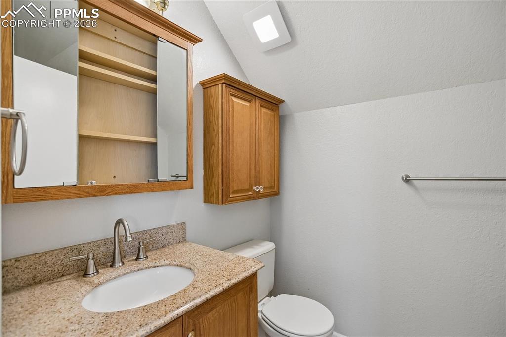 Image 23 of 29: Half bath featuring vanity and vaulted ceiling
