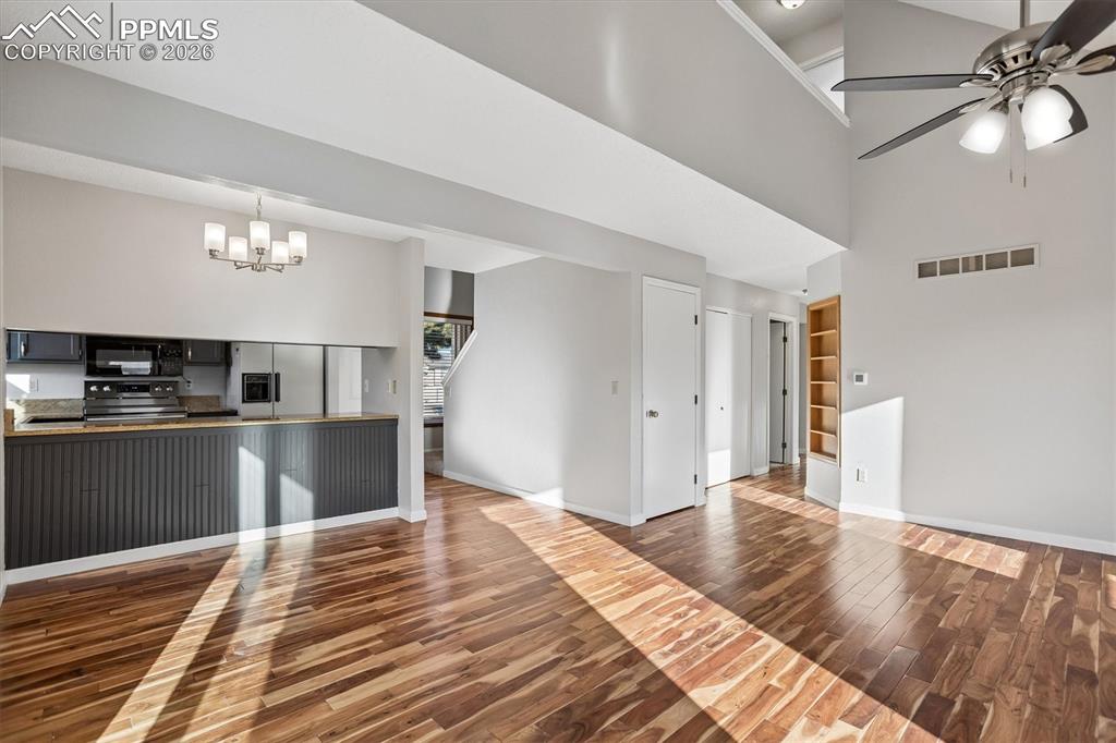 Image 4 of 29: Unfurnished living room with built in features, dark wood-style flooring, a