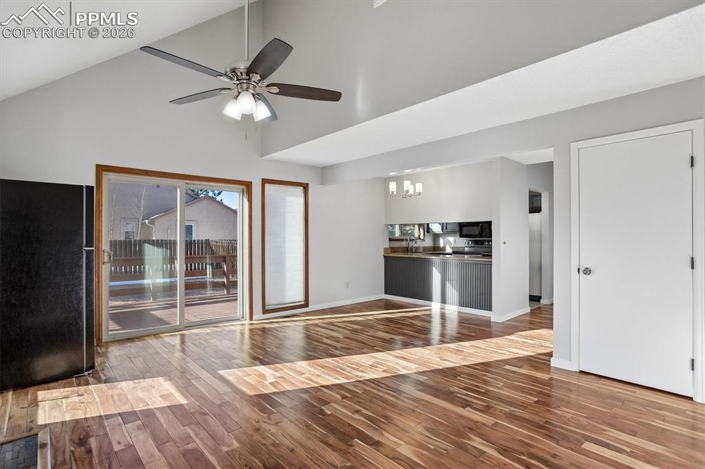 Image 7 of 29: Unfurnished living room with dark wood finished floors, a chandelier, lofte