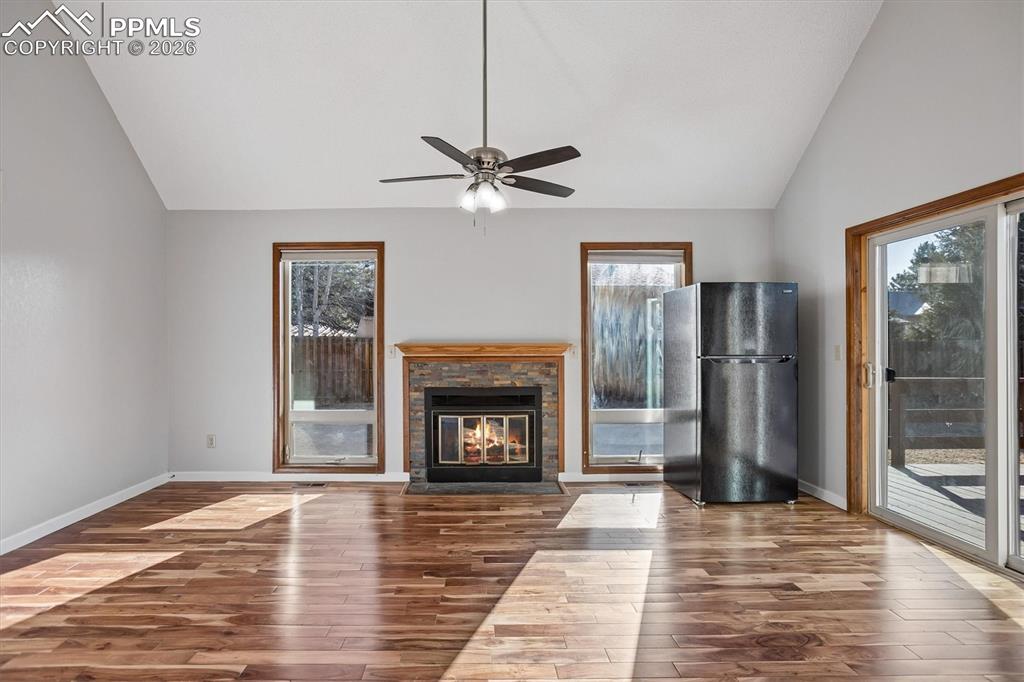 Image 8 of 29: Unfurnished living room with lofted ceiling, hardwood / wood-style flooring