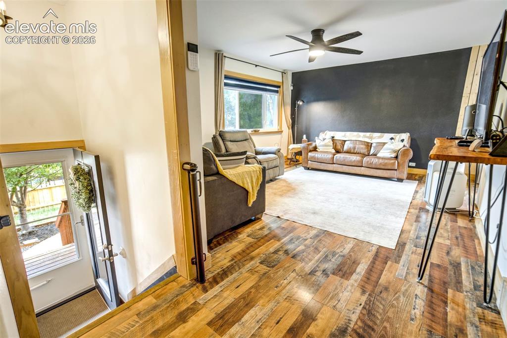Image 10 of 50: Living space featuring wood-finish flooring, a contemporary ceiling fan wit