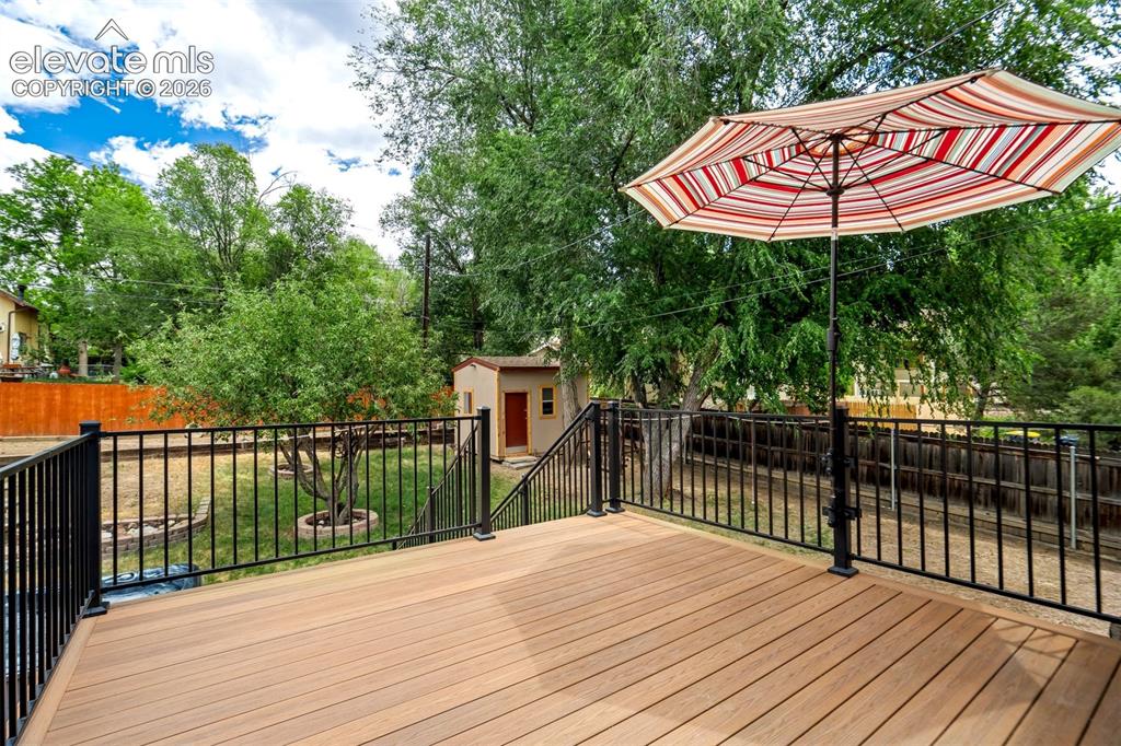 Image 19 of 50: Expansive rear deck featuring wood-finish flooring and black metal railings